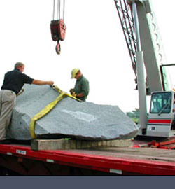 artist rigging sculpture before lifting off truck